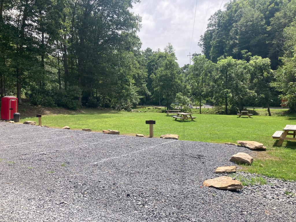 Gravel parking beside the field camping meadow – Field Tent Camping at The Outpost NRG