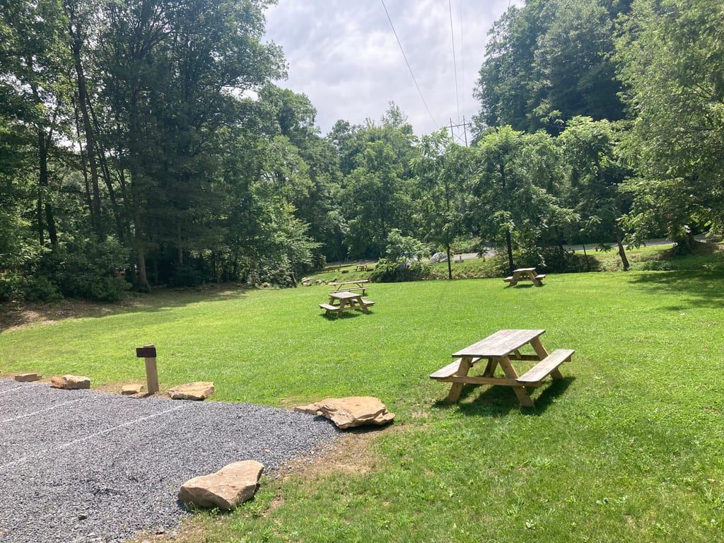 Grassy field with picnic tables – Field Tent Camping at The Outpost NRG