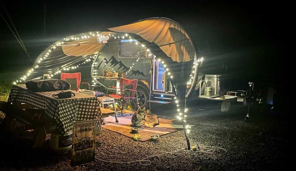 Teardrop camper with lighted awning at a partial hookup site – Partial Hookup RV Site at The Outpost NRG