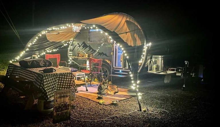 Teardrop camper with lighted awning at a partial hookup site – Partial Hookup RV Site at The Outpost NRG