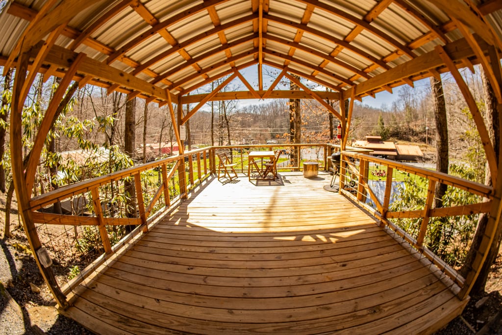 Wide view of a covered tent platform in the forest – Tent Platforms at The Outpost NRG