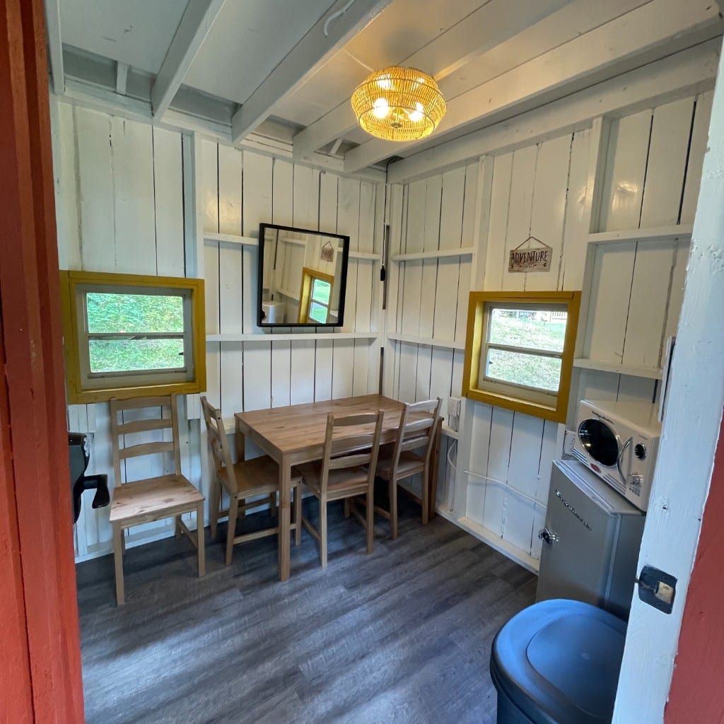 Rustic Family Cabin dining area with table, fridge, and microwave – Rustic Family Cabin at The Outpost NRG