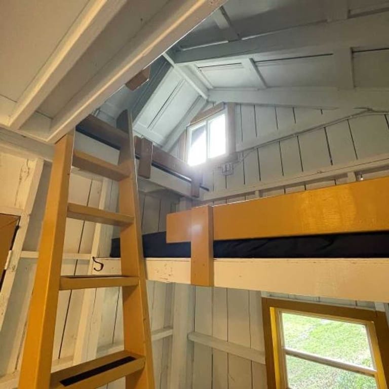 Loft bunk with wooden ladder in the Family Cabin – Rustic Family Cabin at The Outpost NRG