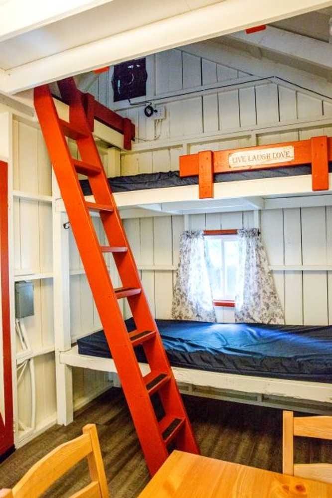 Orange ladder and bunk beds in the Family Cabin – Rustic Family Cabin at The Outpost NRG